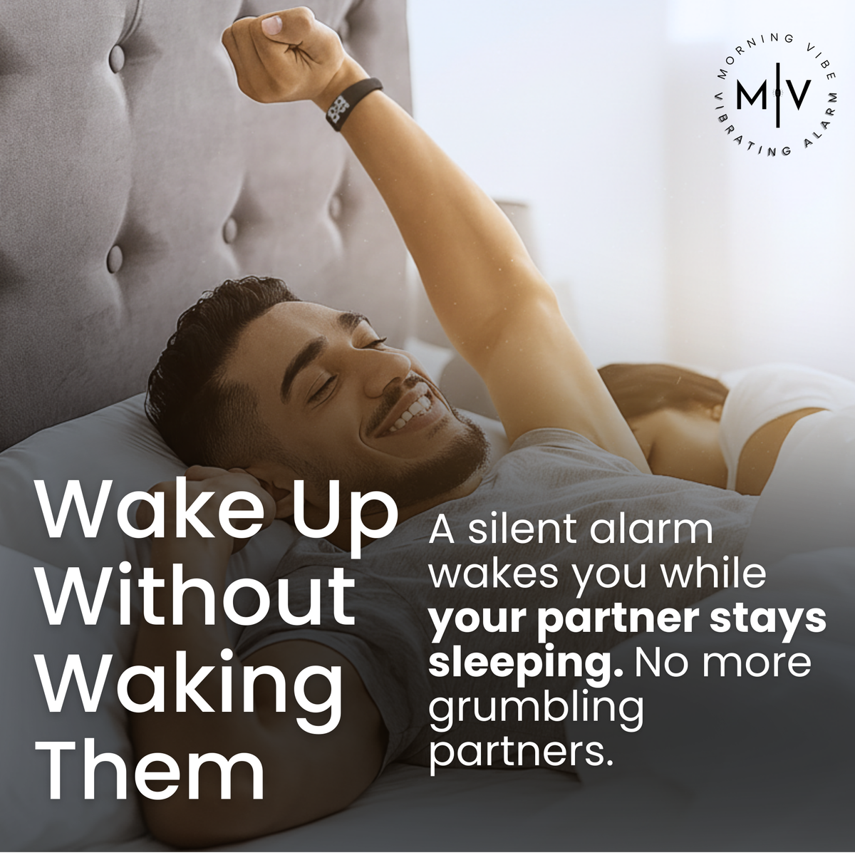 A smiling man stretches in bed while a woman sleeps beside him. Text promotes the Morning Vibe Vibrating Wrist Alarm, which gently vibrates to wake one person without disturbing their partner.